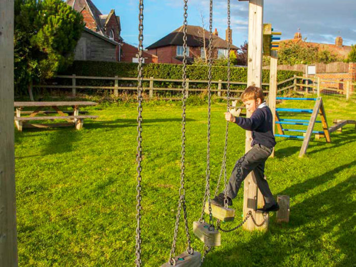 boy using a playground traverse log equipment