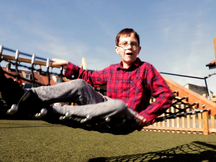 young boy on a playground hammock